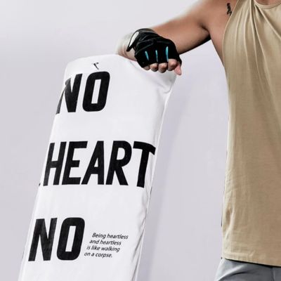 serviette en microfibre blanc et motif lettres sur banc de musculation près de homme debout