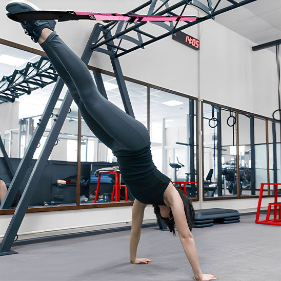 femme fait pompes inclinees avec sangle musculation TRX