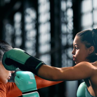 gants-de-boxe-Fiving-12-oz-vert-portes-par-femme-donnant-un-coup-de-poing-pendant-entrainement