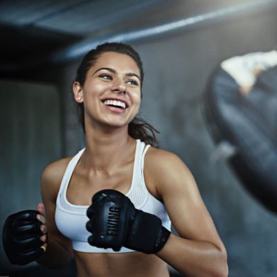 Gants MMA femme debutante qui s apprete a frapper dans  sac de frappe 