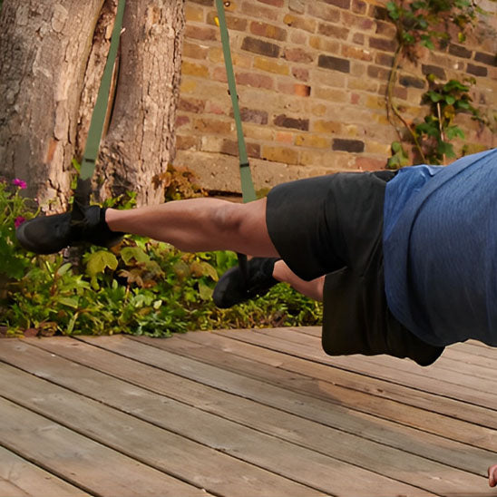 pompes inclinees par homme avec sangle musculation TRX exterieur