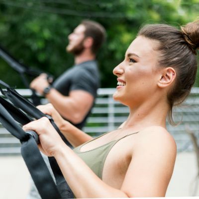 sangle musculation - Femme et homme exécutant rowing en suspension avec sangle musculation TRX 