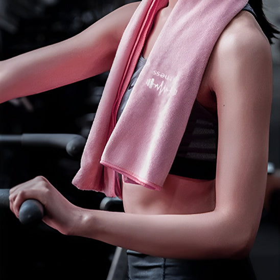 serviette en microfibre rose autour cou de sportive sur tapis de course