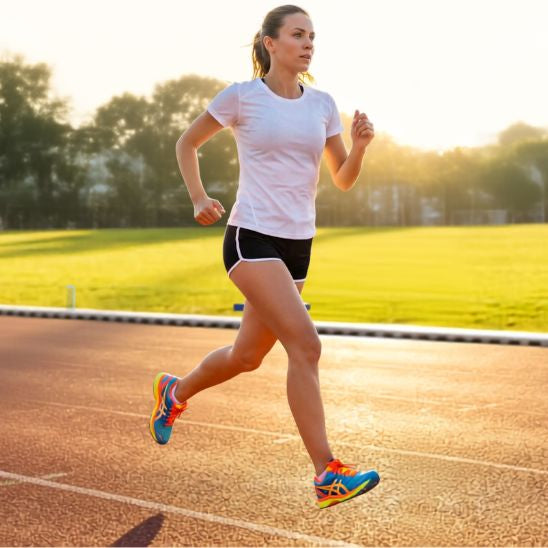 Shorts de sport femme noir - Femme qui court sur une piste d'athlétisme au coucher du soleil – tenue de running légère