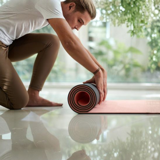 tapis pour le yoga jeune homme enroulant le tapis avec sangle de transport