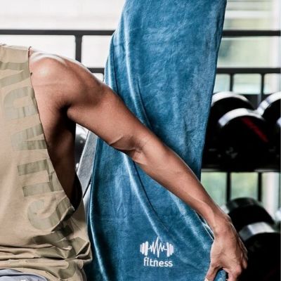 serviette-en-microfibre-essentielle-pour-sports-homme-assis-sur-banc-recouvert-de-cette-serviette-absorbante